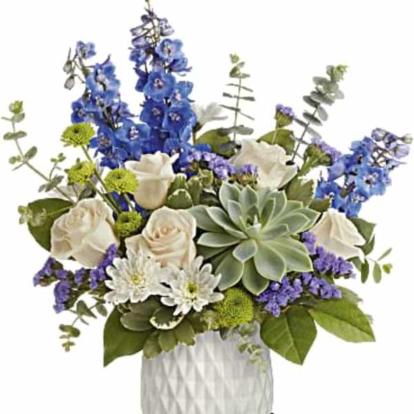 Blue and white floral arrangement in a white vase with a succulent