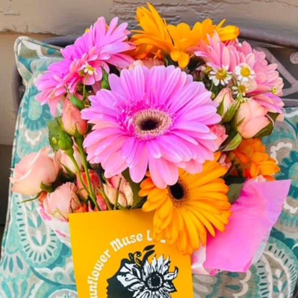 Bouquet of pink and orange gerbera daisies with pale roses and a card