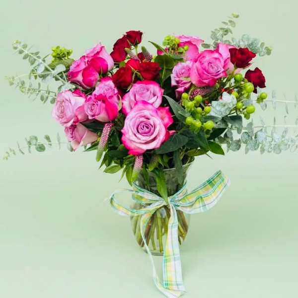Bouquet of pink and red roses in a glass vase with a ribbon
