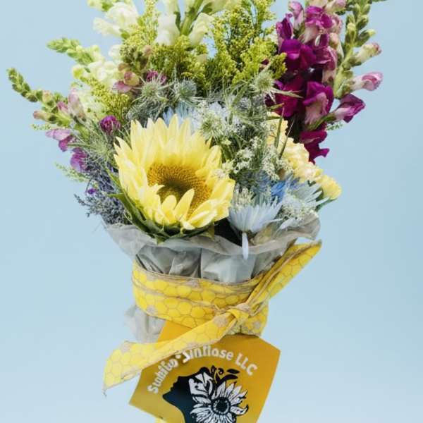 Bouquet with a yellow sunflower and purple snapdragons wrapped in yellow ribbon