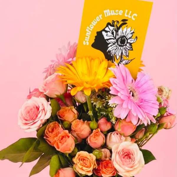 Bouquet of pink and peach roses with gerbera daisies and a yellow card