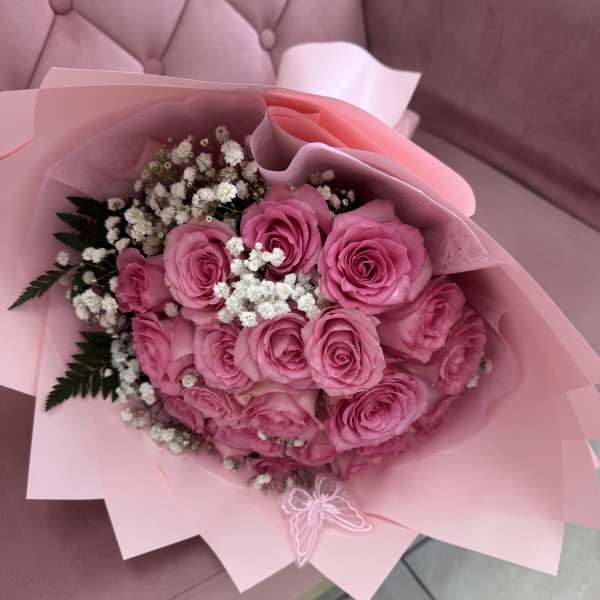 Pink rose bouquet with white baby's breath in pink wrapping