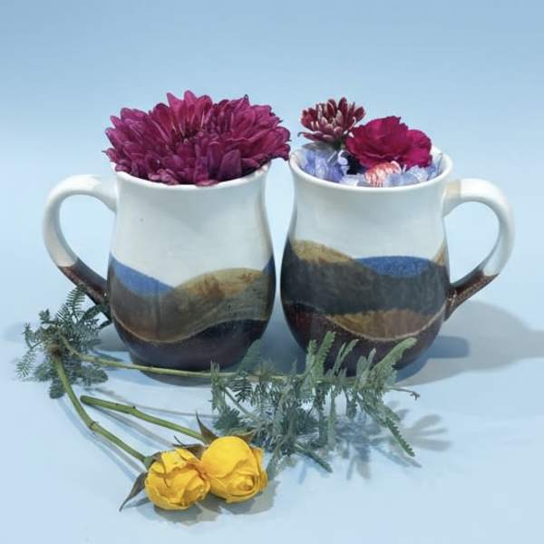 Pair of pottery mugs with wildflowers