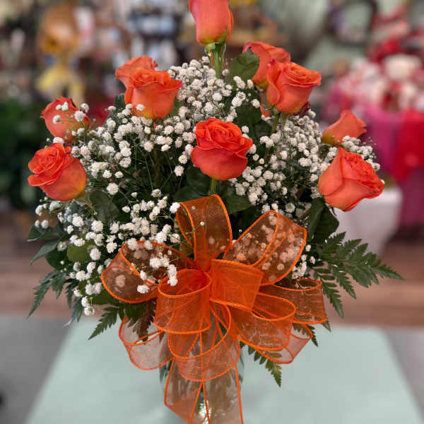 Orange roses with baby's breath and an orange ribbon bow