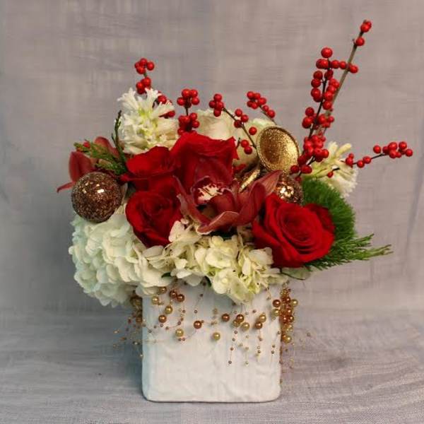Red roses and white flowers in a white vase with gold ornaments