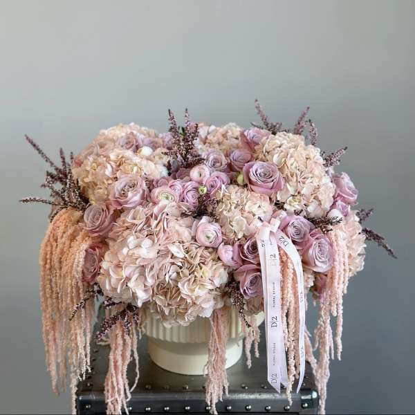 Pink and cream bouquet in a white hat box with trailing ribbons