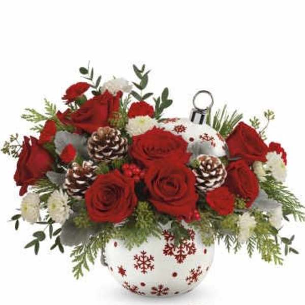 Red roses and white carnations in a snowflake vase with pinecones