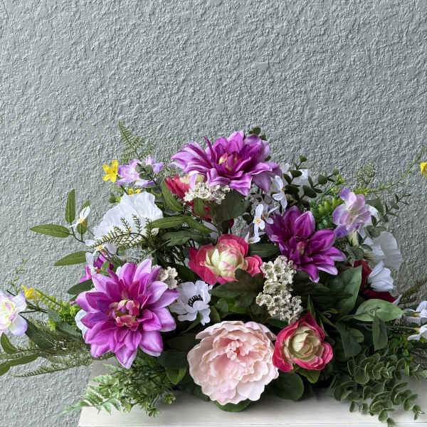 Mixed bouquet of pink, purple, and white flowers in a low arrangement