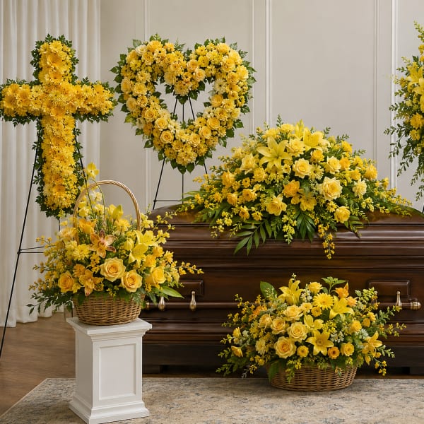 Yellow funeral casket spray with matching standing wreaths and baskets