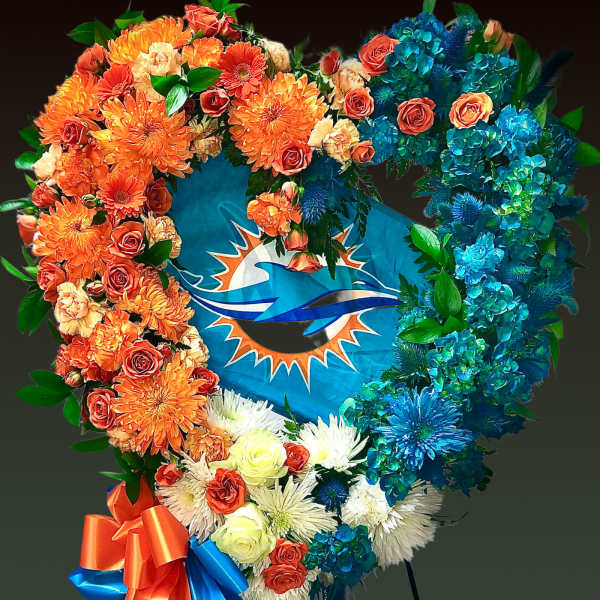 Heart-shaped floral wreath with orange, blue, and white flowers around a Miami Dolphins logo
