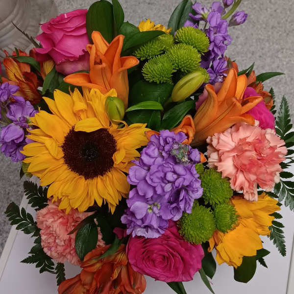 Colorful mixed bouquet with sunflowers, roses, lilies, and purple blooms