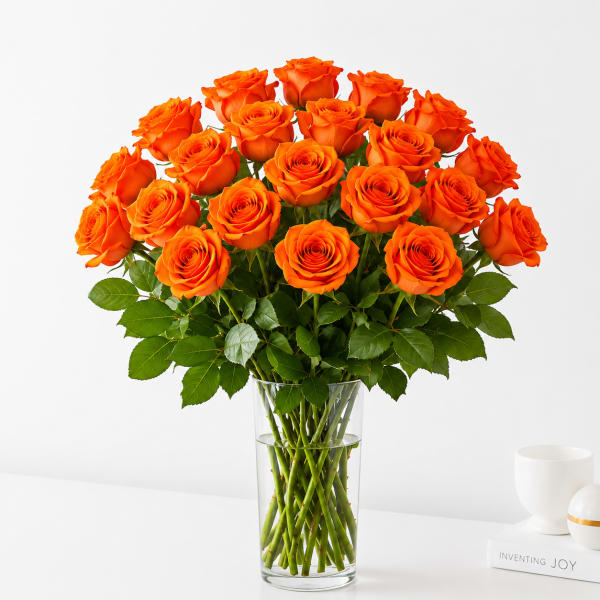 Orange roses arranged in a clear glass vase