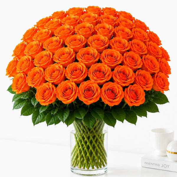 Large bouquet of orange roses in a clear glass vase
