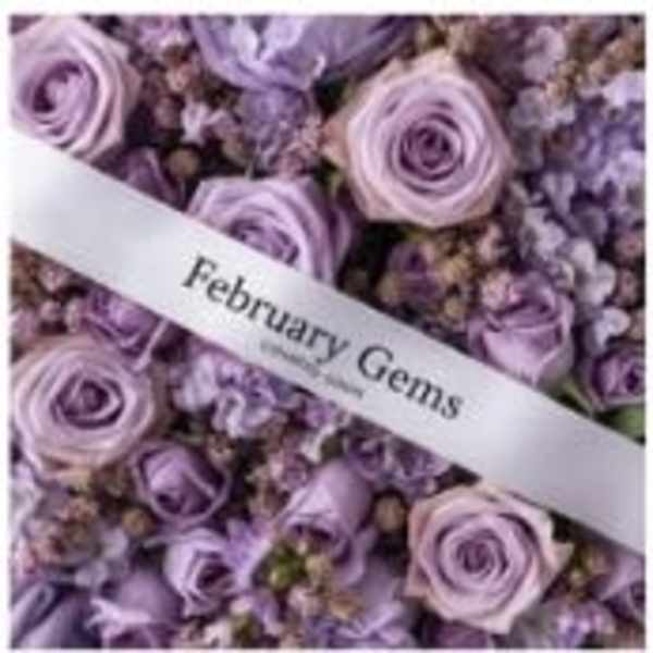 Lavender roses and small purple flowers with a "February Gems" ribbon