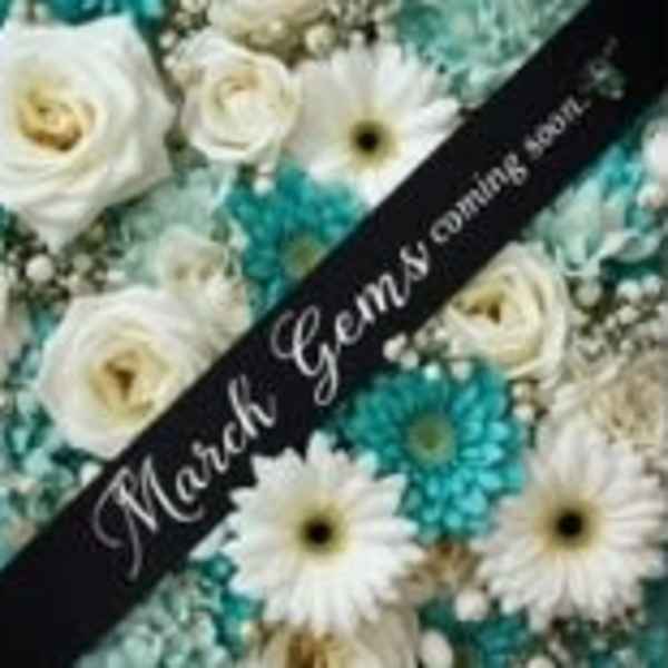 White roses and daisies with turquoise flowers and a memorial ribbon