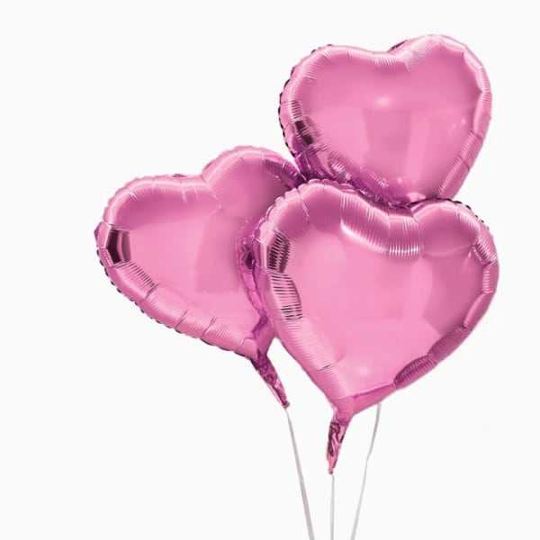 Three pink heart-shaped balloons on sticks