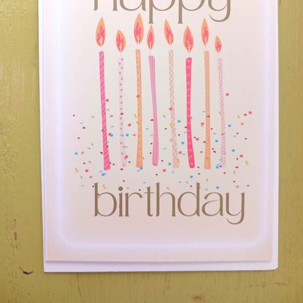 Happy birthday greeting card with tall pink candles and confetti