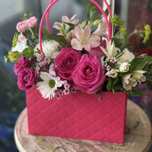 Pink rose bouquet in a bright pink handbag-style container