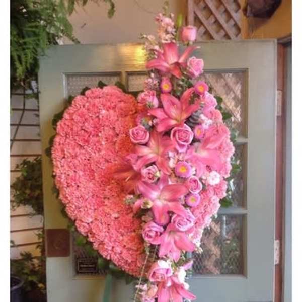 Large pink heart-shaped floral arrangement on an easel