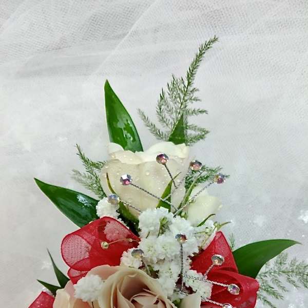 Small bouquet of cream roses with red ribbon and white filler flowers