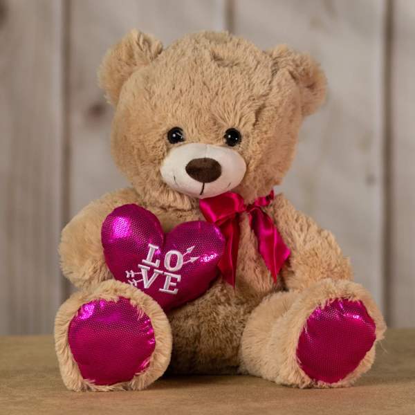 Teddy bear holding a pink heart with "LOVE" text
