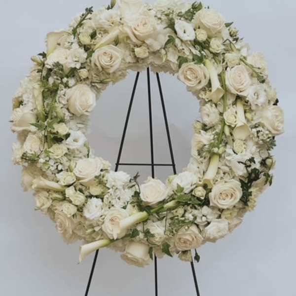Cream floral wreath on a black stand