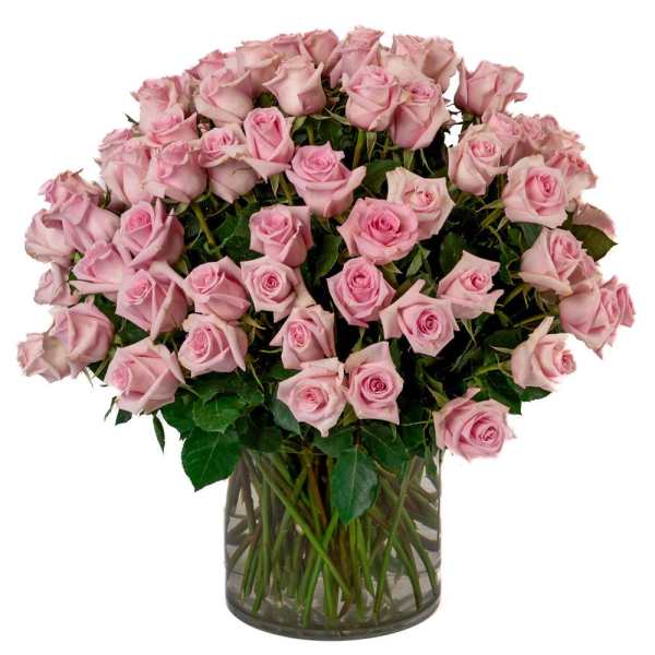Large bouquet of light pink roses arranged in a clear glass vase