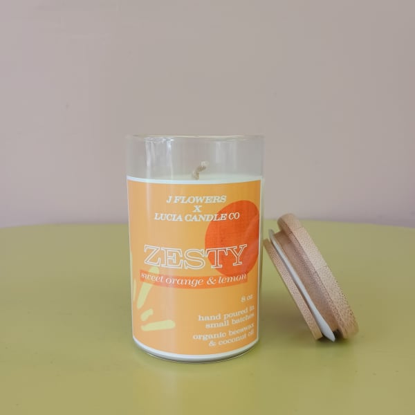 Orange scented candle in a glass jar with a wooden lid