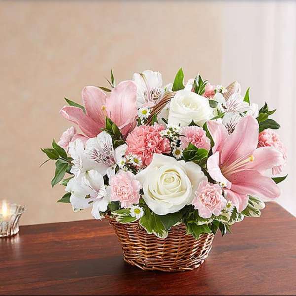 Pink and white flower arrangement in a wicker basket