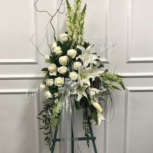 Tall white floral standing spray with roses and lilies on an easel