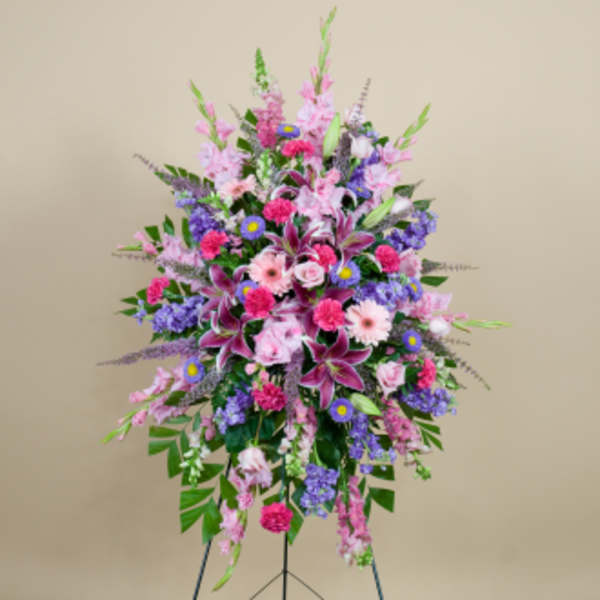 Tall standing spray of pink, purple, and white flowers on a stand