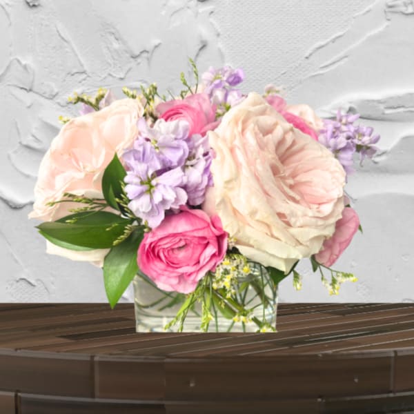 Pink and cream roses arranged in a clear glass vase