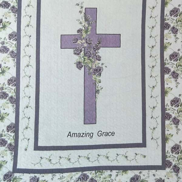 Quilt with a purple cross and floral border, labeled "Amazing Grace"