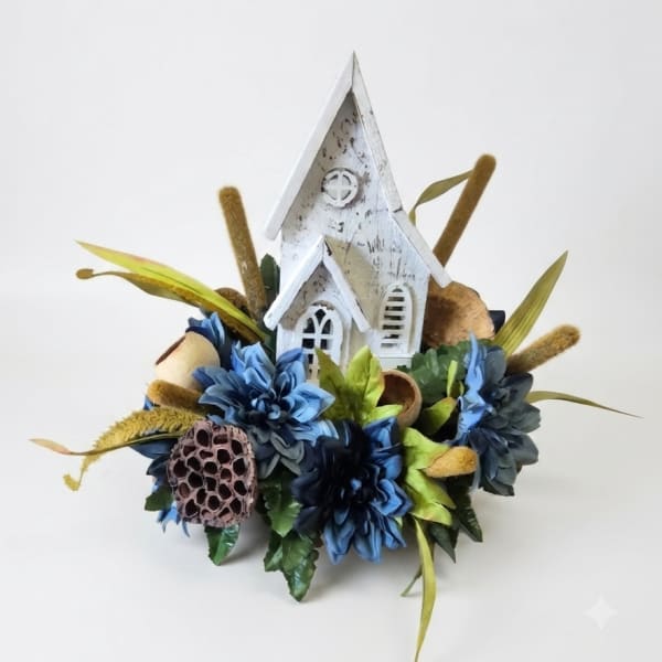 Blue floral arrangement with a white decorative church centerpiece