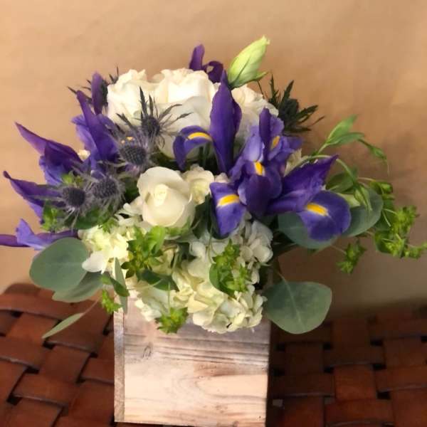 Purple irises and white roses in a wooden box