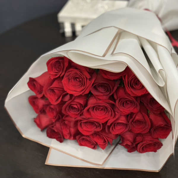 Bouquet of red roses wrapped in white paper