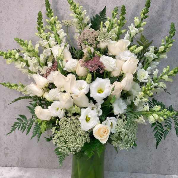 White floral arrangement in a tall glass vase