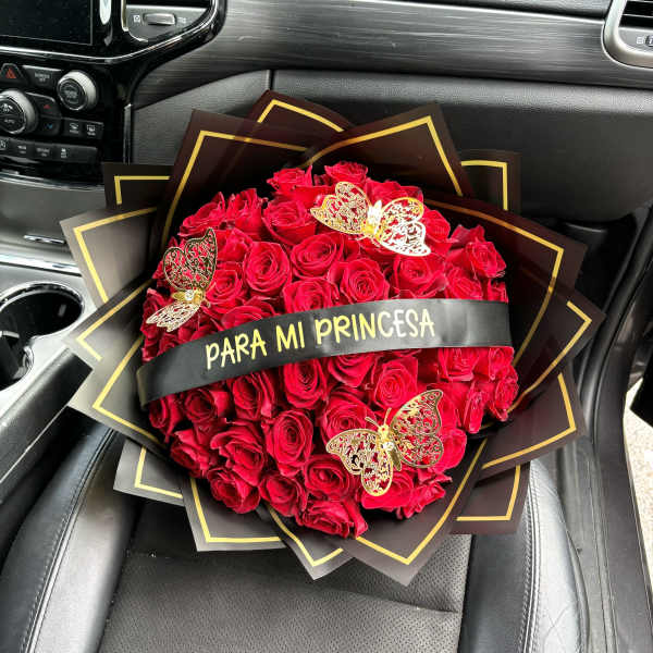 Bouquet of red roses with butterfly decorations and a ribbon reading "PARA MI PRINCESA"