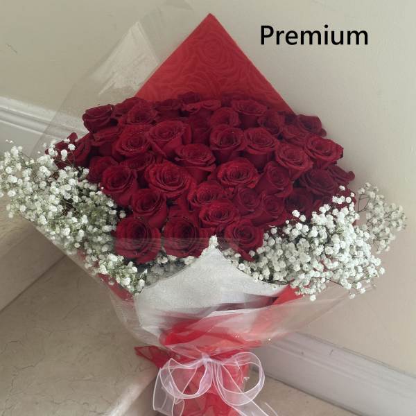 Bouquet of red roses with white baby's breath wrapped in red and clear paper