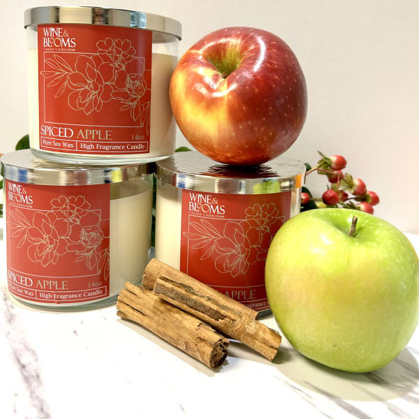 Three spiced apple candles with apples and cinnamon sticks