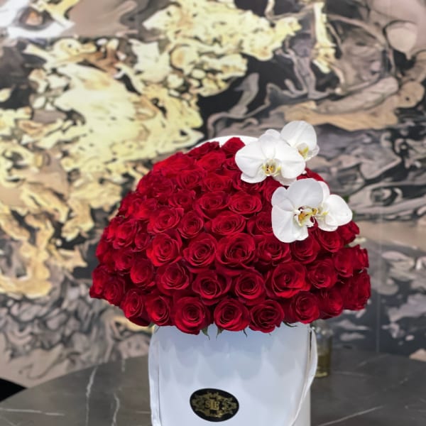 Red rose arrangement in a white hatbox with white orchids