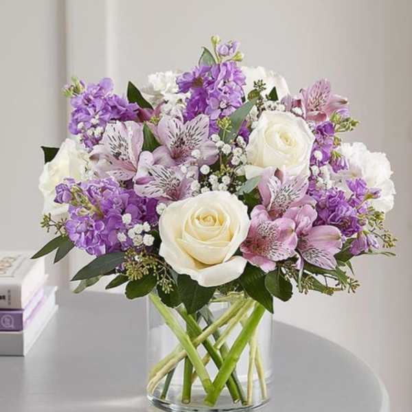 Purple and white bouquet in a clear glass vase