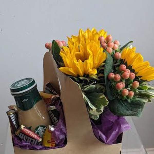 Sunflower bouquet with berries and a coffee cup in a gift box