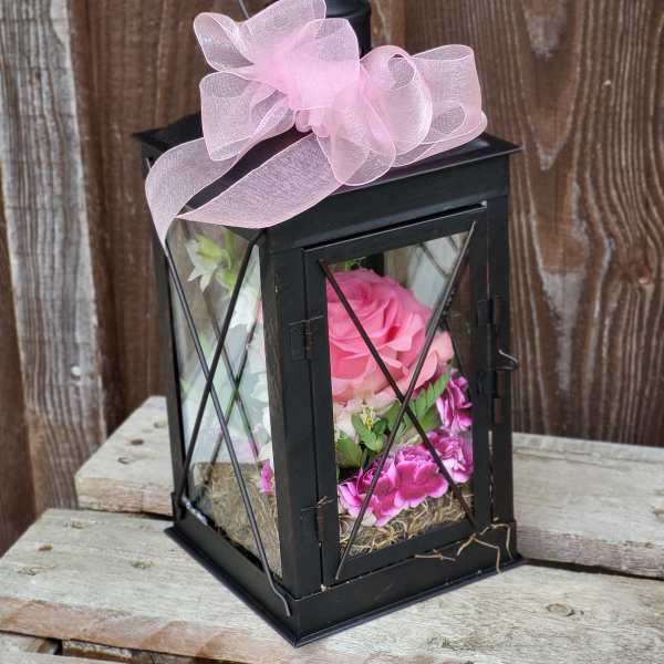 Black lantern with pink flowers and a pink bow