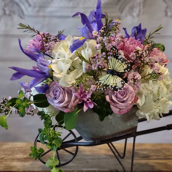 Mixed bouquet in a metal container with purple, pink, and white flowers