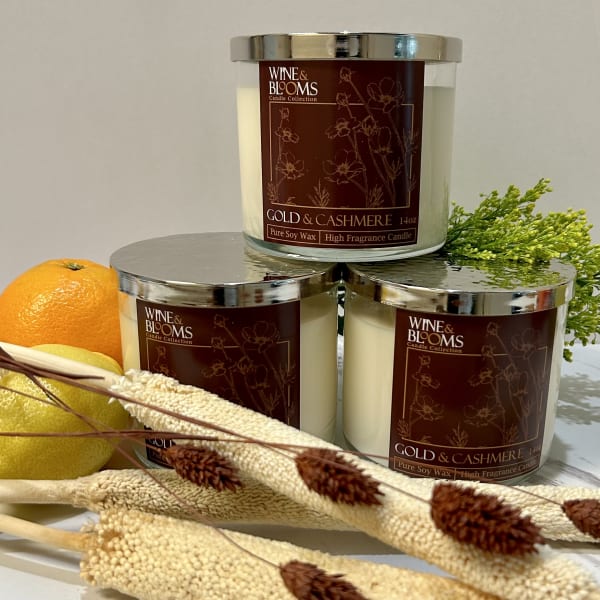 Three scented candles with citrus and dried floral accents
