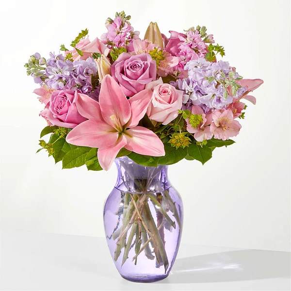 Pink and lavender bouquet in a purple glass vase