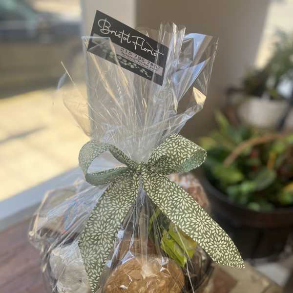Wrapped gift basket with cookies and a ribbon bow