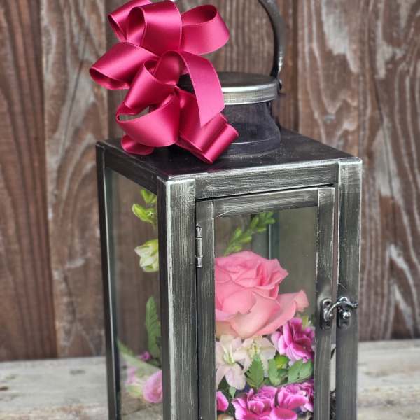 Black lantern with pink flowers and a magenta ribbon bow