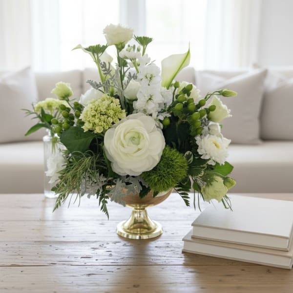 White and green floral arrangement in a gold pedestal vase